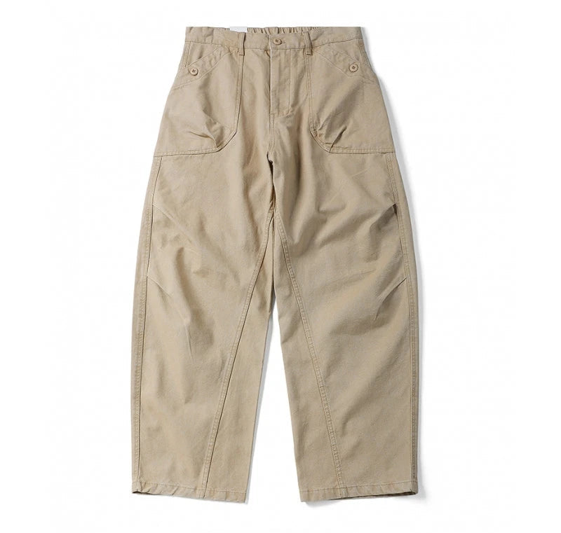 A pair of beige wide-leg cargo pants with a relaxed, straight-to-slightly-bulged leg, featuring large front flap pockets and button details at the waistband, laid flat on a white background.