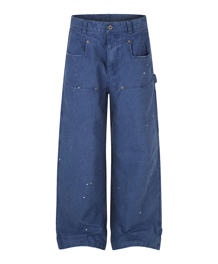 A pair of wide-leg blue denim pants with paint splatter details, shown flat against a white background.