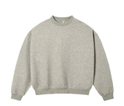 A light oat grey crewneck sweatshirt laid flat against a textured off-white background, with 'OAT GREY' text printed below it.