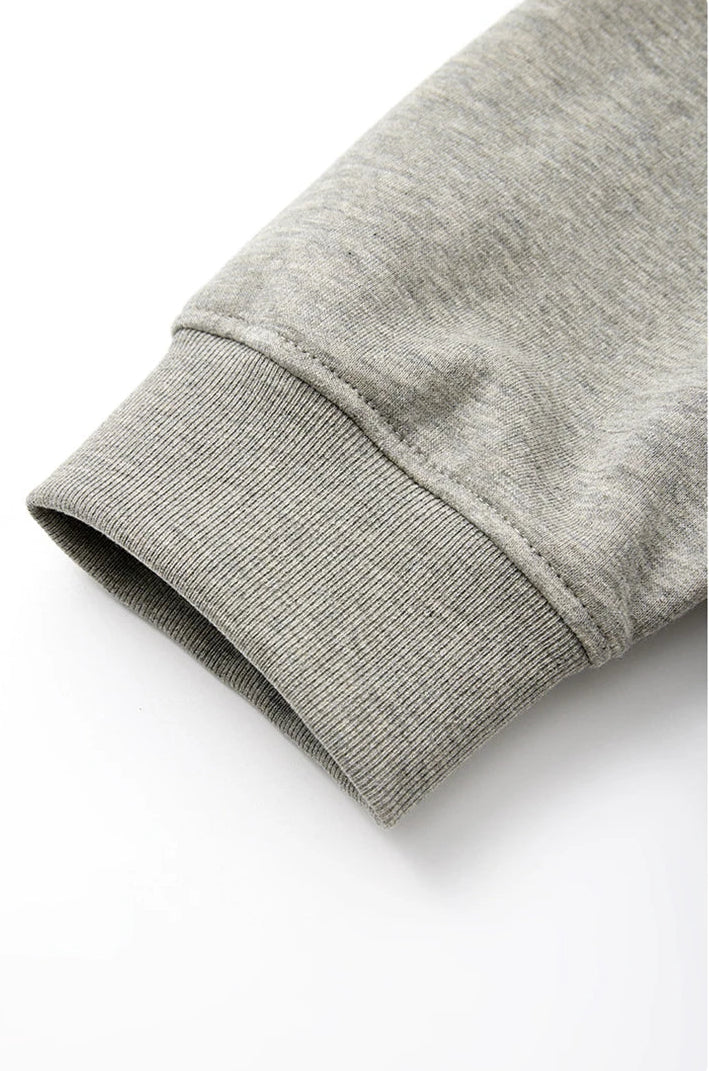 Close-up of a light gray ribbed cuff on a sweatshirt sleeve, with Chinese text at the bottom describing the elastic ribbed cuff feature.