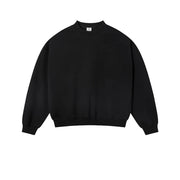 A plain black crewneck sweatshirt laid flat against a light textured background, with the word BLACK centered below it.