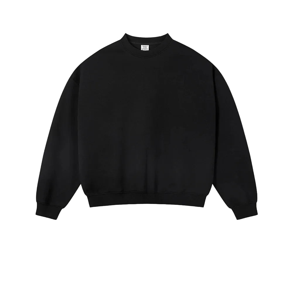 A plain black crewneck sweatshirt laid flat against a light textured background, with the word BLACK centered below it.