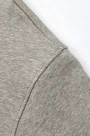 Close-up of a heather gray fabric garment detail with a clean seam and a line of Chinese text below on a white background.