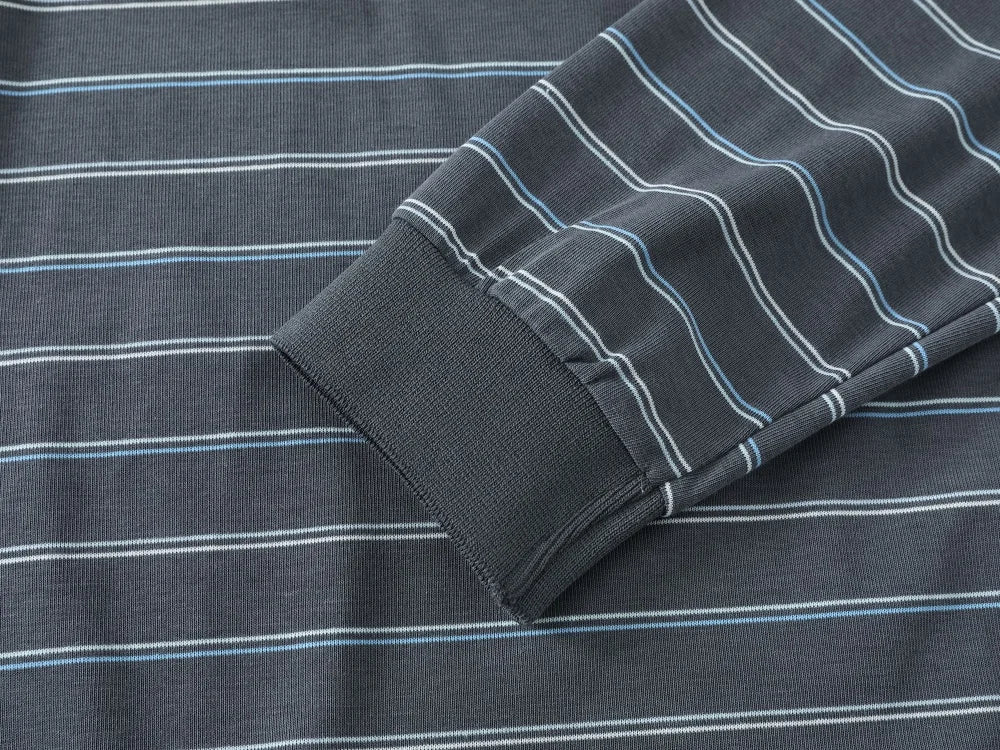 Close-up of a dark gray ribbed knit fabric with thin white and light blue horizontal stripes, showing a folded cuff detail.
