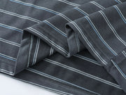 Close-up of a dark gray striped fabric with thin white and light blue pinstripes, folded to show the texture and stitching.