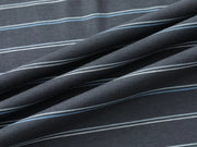 A close-up of draped fabric with a dark charcoal gray base and thin horizontal stripes in white and light blue.