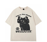 An off-white short-sleeve t-shirt with a black graphic of a three-headed cat, the text 'stare the abyss' above it, and 'VENCEDE' below it, displayed on a clean white background.